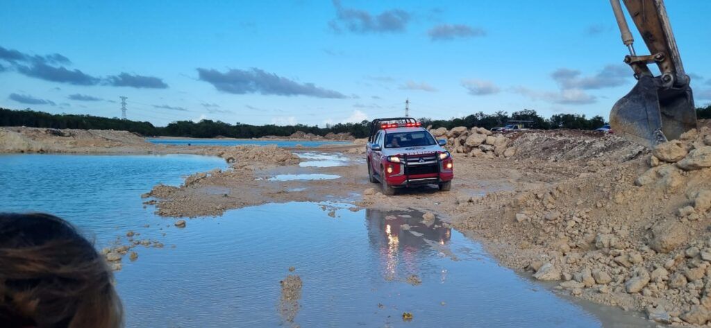 Muere conductor de camión góndola al volcarse en laguna artificial