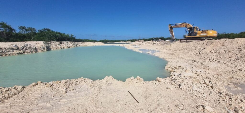 Muere conductor de camión góndola al volcarse en laguna artificial